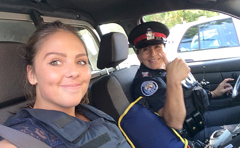 Two women in a police vehicle, one in uniform