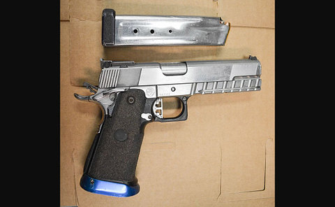 A silver handgun and clip on cardboard