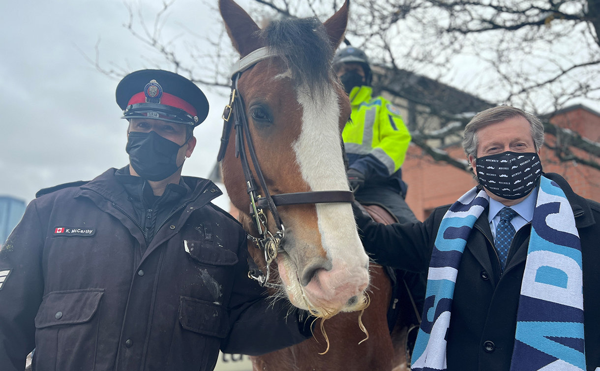 A police officer, a horse and another man