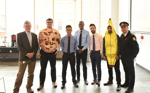 Men standing together, one dressed as cookie, another as a banana