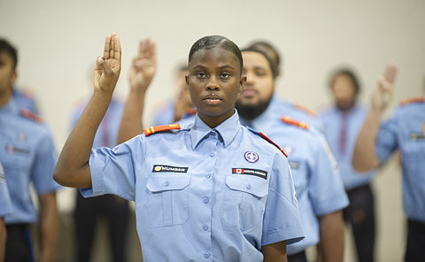 A woman in TPS rover uniform with her hand raised