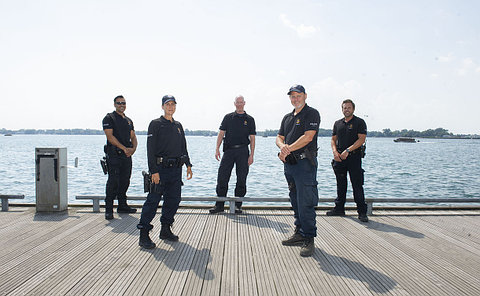 A group of people in TPS uniform on a lakefront boardwalk