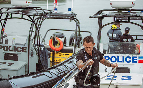 A police officer holding a rope on a boat